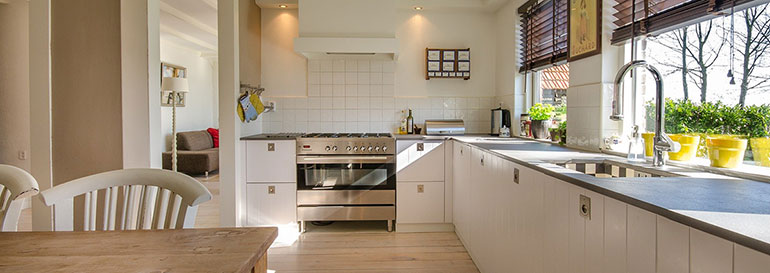 Küche mit Boden in Holzoptik und weißem Fliesenspiegel über dem Herd