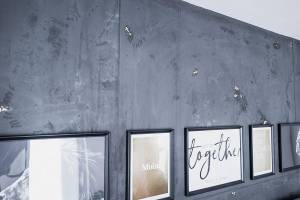 Dunkle Kalk-Marmorputz-Wand mit schwarzen Bilderrahmen